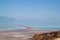 Hazy view of the Dead Sea, Judean Desert, Jordanian mountains, salt deposits, and rocky ridges