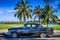 HDR - American black vintage car parked under palms near the beach in Varadero Cuba - Serie Cuba Reportage