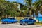 HDR - American blue classic cars with white roof parked on the beach under palms in Varadero Cuba - Serie Cuba