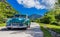 HDR - Blue green american vintage car drives on the countrystreet in the countryside from Trinidad Cuba - Serie Cuba Reportage