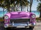 HDR Cuba pink american classic car parked under palms near the beach in Varadero