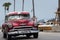 HDR Cuba red american Oldtimer drives on the Malecon Promenade in Havana