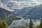 HDR landscape view of mountains with dramatic cloudy sky above a lake near Hallstatt village in Austria.