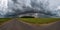 Hdr panorama on asphalt road among fields in evening with awesome black clouds before storm