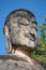 The head of an ancient Buddha statue closeup. The ruins of the ancient Buddhist temple Wat Phra Kaeo. Kamphaeng Phet, Thailand