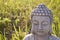 Head of Buddha on sunny meadow.
