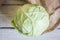 Head of cabbage on sackcloth on white wooden table, top view