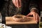 The head chef adds spices to the homemade sausage lying on the cutting board. Chef hands close up. Working environment in the