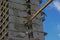 Head of a crane demolishing a stripped down apartment building