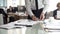 Head of department signing documents, employees working on background, office