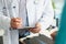 Head doctor in medical gown put sign on clipboard with prescription paper