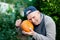 Head gardener checks the ripeness of the pumpkin. The 87 - year-old farmer enjoys the pumpkin harvest in the garden. Cheerful