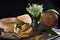 A head of hard cheese and a bouquet of lilies of the valley on a black background. . Photo on a black background. Top view