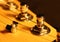 The head of the neck of an electric guitar stratocaster with pegs and strings. Artistic photo of a stringed wooden musical