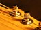 The head of the neck of an electric guitar stratocaster with pegs and strings. Artistic photo of a stringed wooden musical