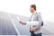 Head with a notepad in his hand and a coiled project on a background of solar panels