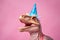 Head of pastel colored dinosaur with party hat on pink background