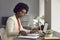Head shot afro-american woman working with financial documents and laptop