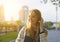 Head shot of blond smiling woman walking on street and dreamy looking aside