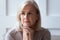 Head shot close up portrait of thoughtful retired woman.