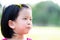 Head shot. Happy face of Asian child girl. Sweet smiling kid in the nature. Children attach hairpins in front of their hair.