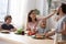 Head shot happy full family sitting at huge kitchen table.