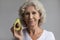 Head shot portrait beautiful middle aged woman holding avocado