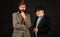 Head shot portrait of elderly mature dad and grownup son. Two male generations family. Men in hat on dark studio