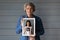 Head shot portrait mature woman holding photo, three generations concept