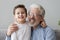 Head shot portrait smiling grandfather hugging cute little grandson