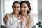 Head shot portrait smiling middle aged mother hugging grownup daughter