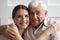 Head shot portrait smiling older father and adult daughter hugging