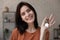 Head shot portrait smiling woman showing keys to new apartment