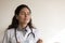 Head shot relaxed female doctor taking off medical face mask