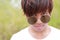 Head shot of Thai male teenager in white t-shirt and sunglasses is staring at camera.