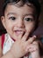 A head shot vertical portrait of an adorable indian baby looking at the camera with selective focus on eyes