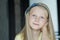 Head and shoulders indoors portrait of teenage girl with blue eyes and fair hair