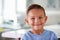 Head And Shoulders Portrait Of Smiling Hispanic Boy At Home