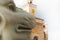 The head of a statue of a lion on the background of a historic building