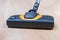 Head of Vacuum Cleaner sweeping laminate floor.