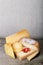 Head and various pieces of cheese on a wooden table. Vertical