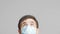 Head of a young man in protective surgical mask looking up and watching news with eyes, concept of health and medicine,emotions of