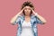 Headache, thinking or confusion. Portrait of sad young woman with curly hair in casual blue shirt standing and holding her painful