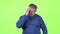 Headache torments middle aged man. Green screen. Slow motion