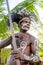 Headhunter of Asmat tribe with a traditional painting on a face, headdress from cassowary feathers