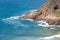 Headland jutting into the sea with railway tunnel and tracks next to bay