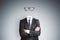 Headless invisible businessman in suit with folded arms and abstract glasses standing on gray wall background. Business and secret