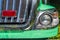 Headlight and Chrome Grille of a Green Fire Truck