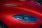Headlight details of a red Aston Martin DBS Superleggera sports car