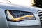 Headlight turned on in Clean car after Washing luxury silver car. Sedan car exterior of modern luxury car during sunset